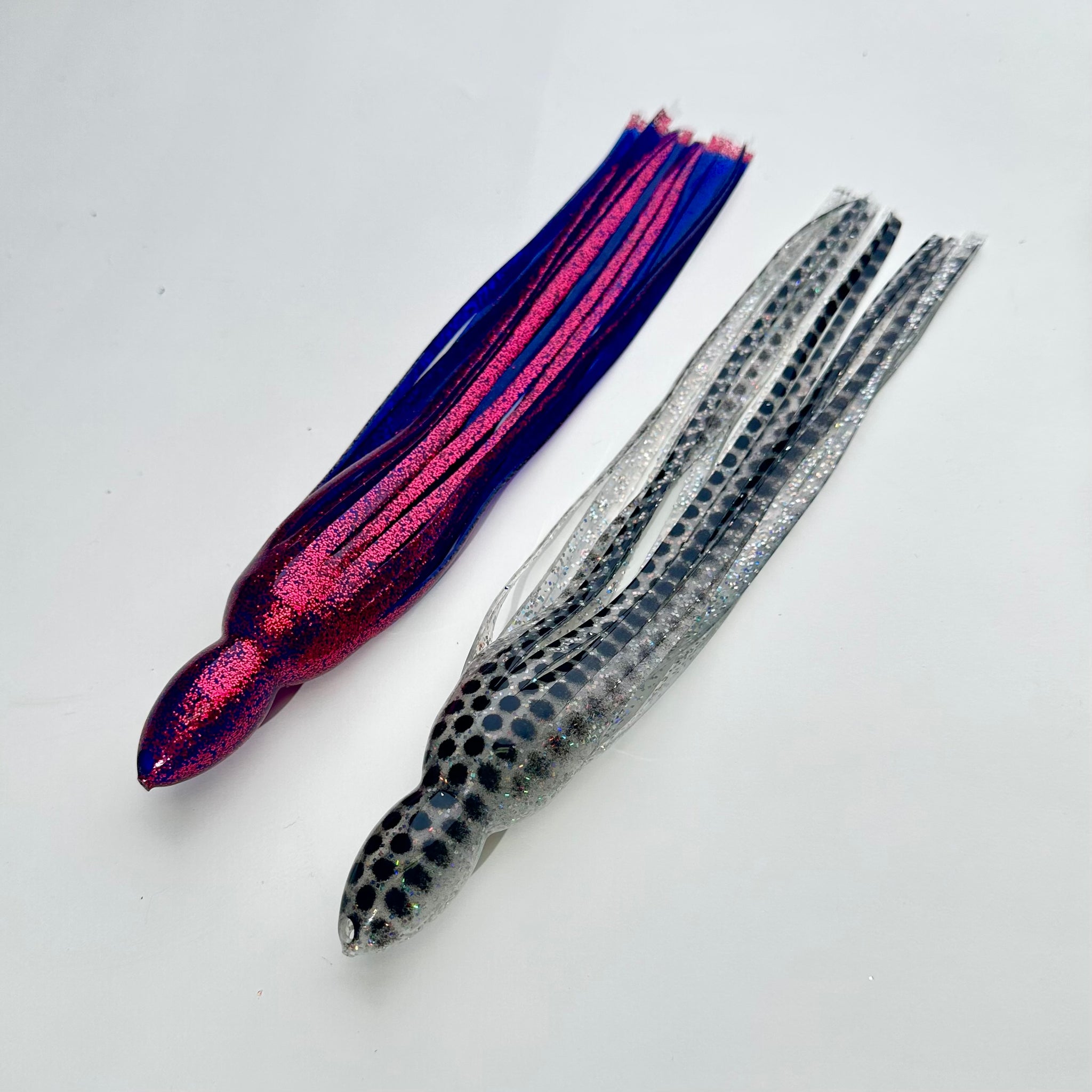 Loose trolling lure skirts before tying: pink and blue glitter skirt next to a silver skirt with black dots